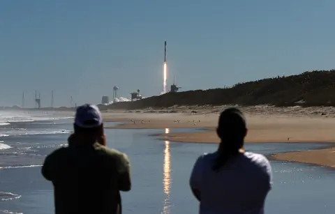 Getty Images People watch from Cape Canaveral, Florida, as SpaceX launch 49 Starlink satellites on board a Falcon 9 rocket 