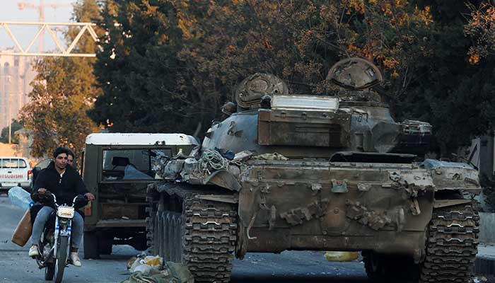 People on a bike ride past a tank that belonged to the Syrian Army, after Syrian rebels announced that they have ousted Syrias Bashar al-Assad, in Damascus, Syria, December 8, 2024. — Reuters