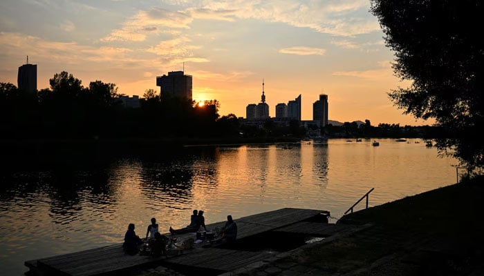 People enjoy the sunset at Alte Donau, an abandoned meander of the river Danube during a heat wave in Vienna, Austria, August 14, 2024. — Reuters