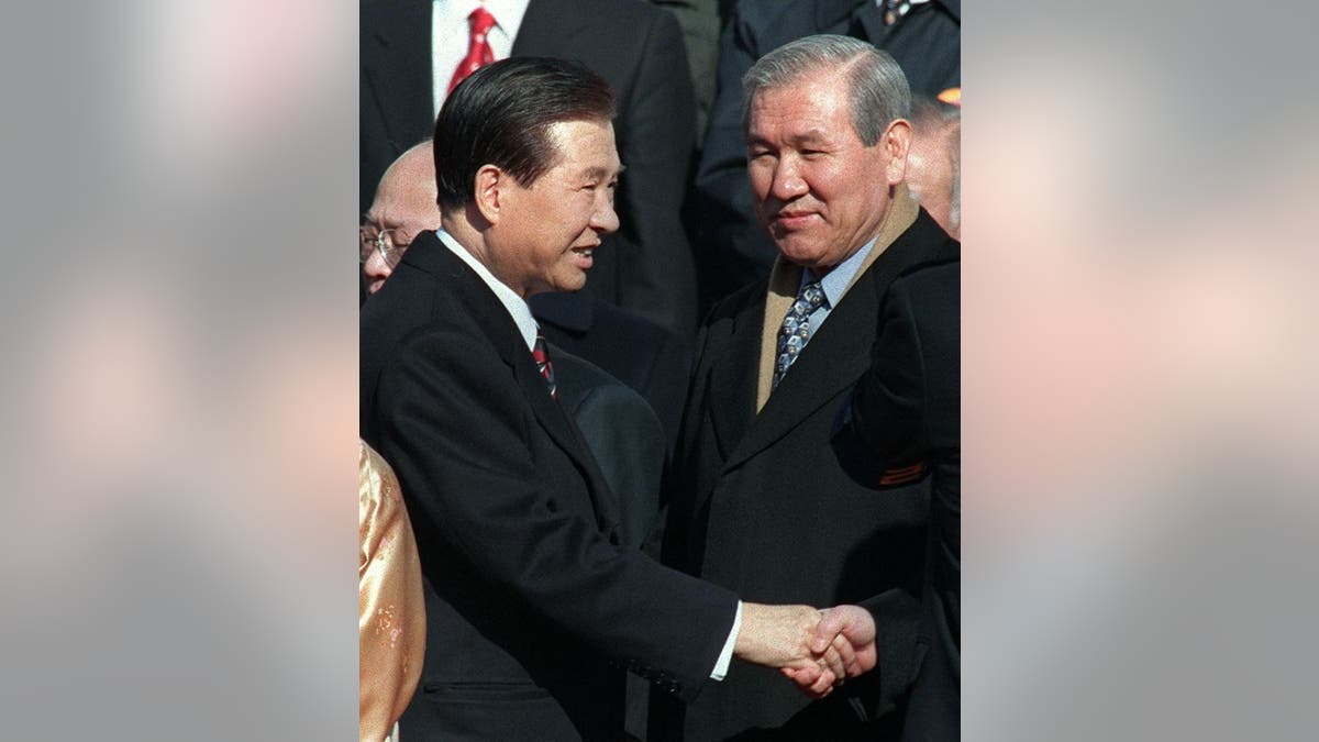 FILE: Jailed former president Roh Tae-Woo (R) looks on as South Korean new President Kim Dae-Jung (L) shakes hands with jailed former president Chun Doo-Hwan (not in picture)  before taking the oath as President during the ceremony of the Inauguration at the National Assembly in Seoul 25 February, 1998.      