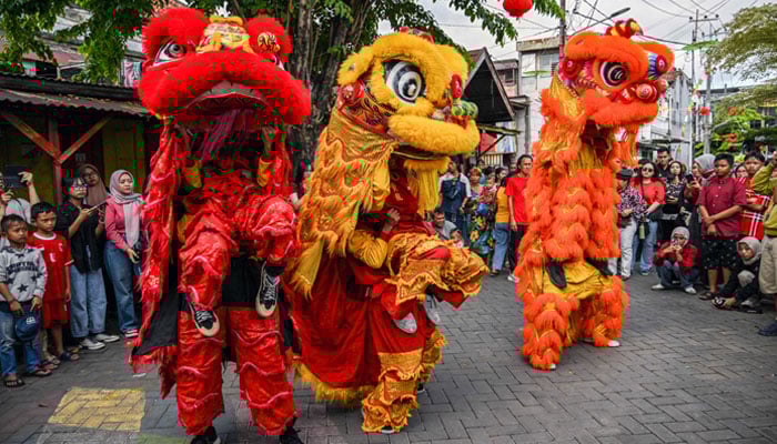 Lion dancers perform for the crowd on the first day of the Lunar New Year of the Snake at Chinatown in Surabaya on January 29, 2025. — AFP