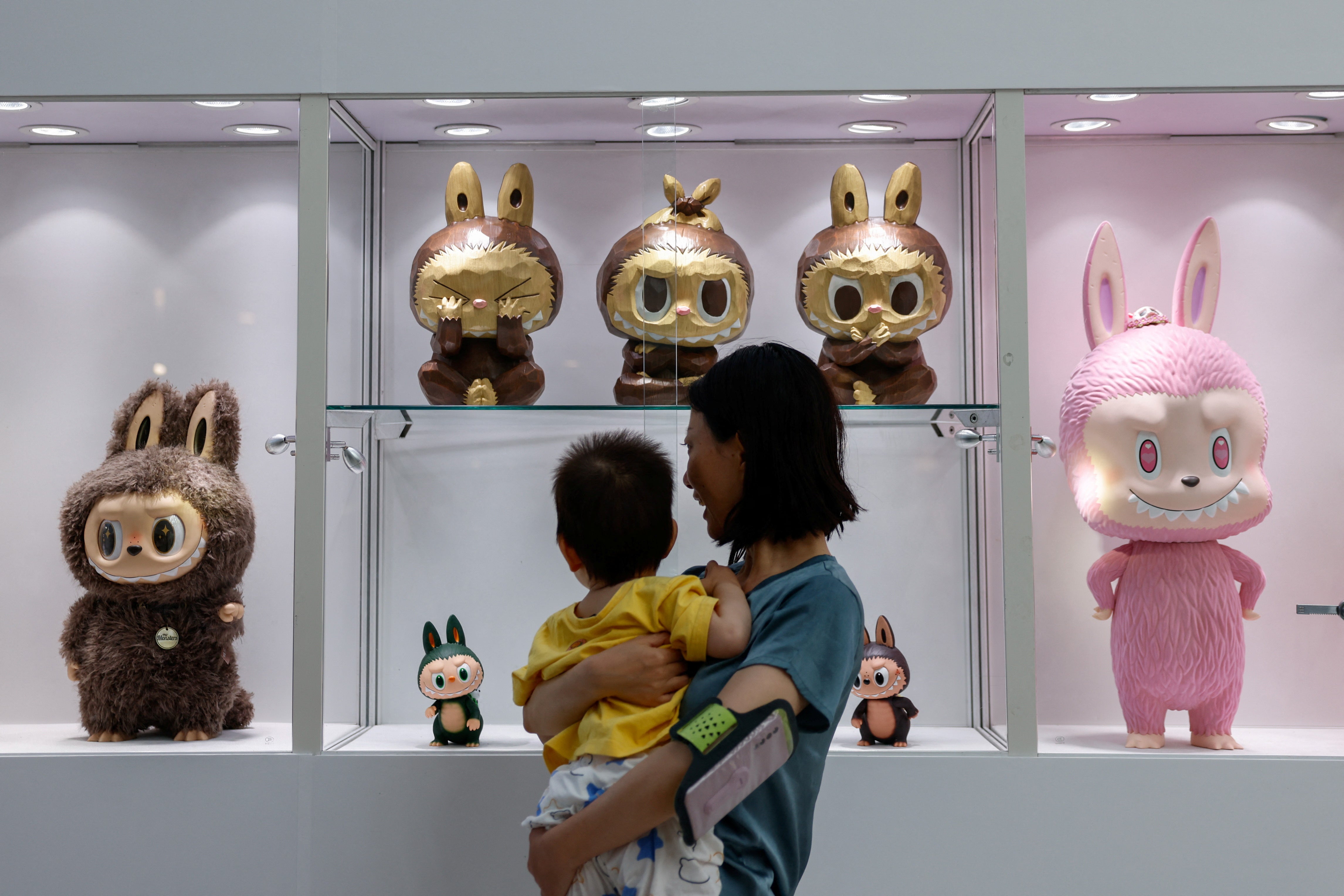 Visitors look at a set of three Labubu sculptures from a series called 'Three Wise Labubu' at a preview exhibition of Yongle International Auction, in Beijing, China 6 June 2025